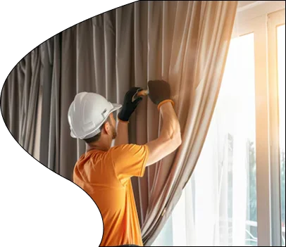 Worker steam cleaning curtains
